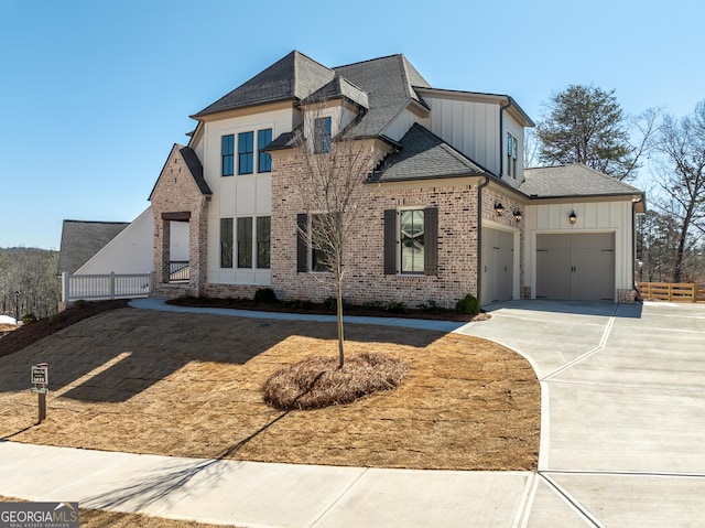 view of front of house with brick siding, a shingled roof, concrete driveway, board and batten siding, and a garage