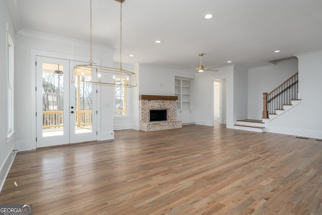 unfurnished living room with stairs, ornamental molding, and a wealth of natural light