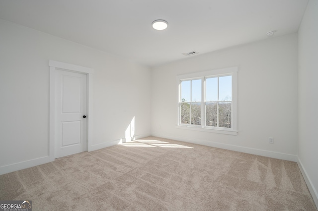 carpeted empty room with baseboards and visible vents