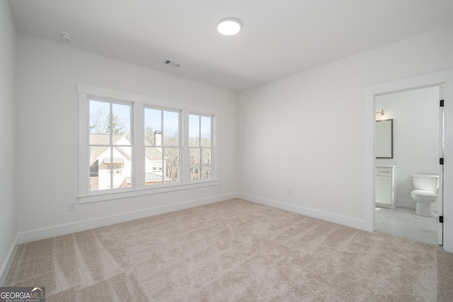 unfurnished bedroom with carpet, visible vents, connected bathroom, and baseboards