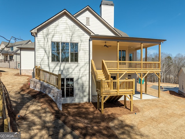 rear view of property with a chimney, a deck, and stairs