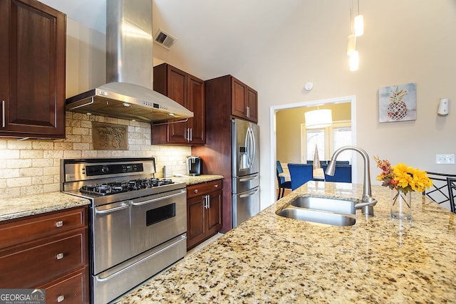 kitchen featuring light stone counters, sink, wall chimney exhaust hood, and appliances with stainless steel finishes