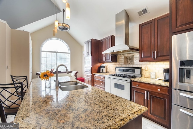 kitchen with sink, stainless steel refrigerator with ice dispenser, wall chimney exhaust hood, gas range oven, and light stone counters