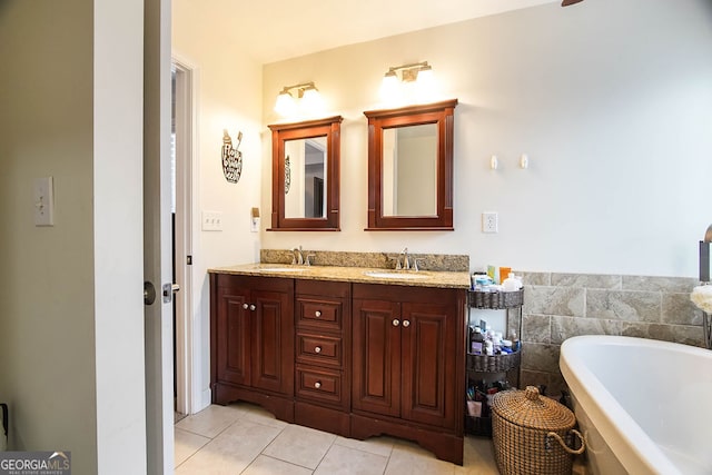 bathroom with tile patterned floors, a washtub, tile walls, and vanity