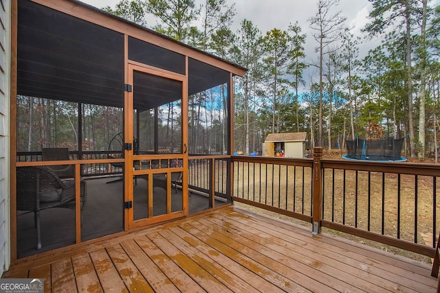 wooden terrace featuring a sunroom and a trampoline