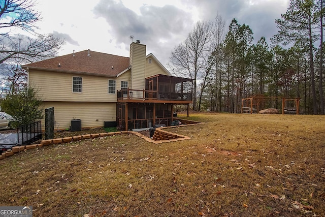 rear view of property featuring a sunroom, cooling unit, and a lawn