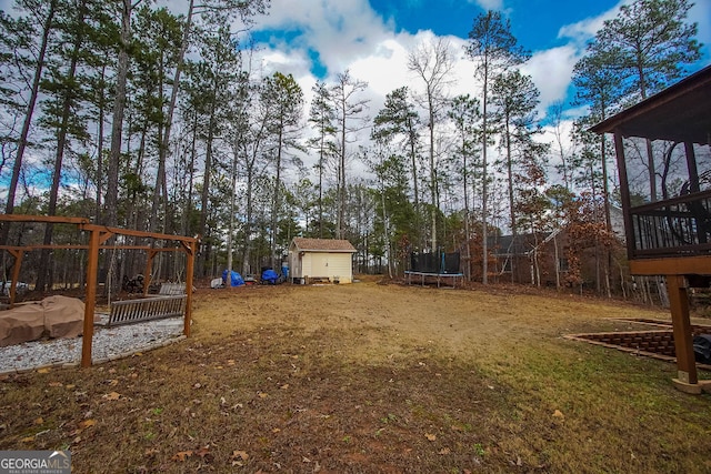 view of yard featuring a playground, a shed, and a trampoline