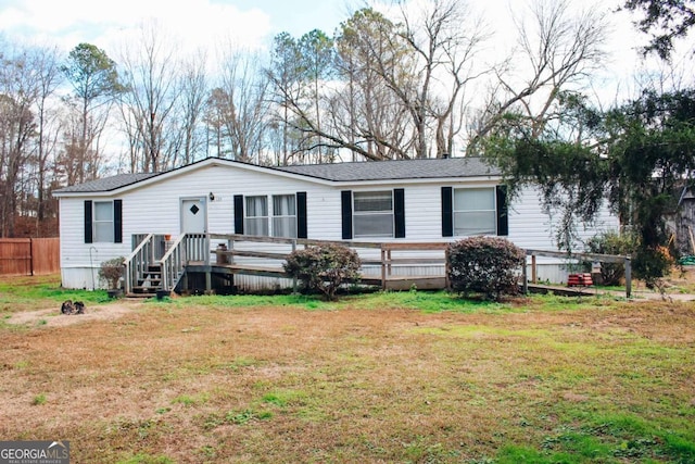 view of front of house with a front yard and a deck