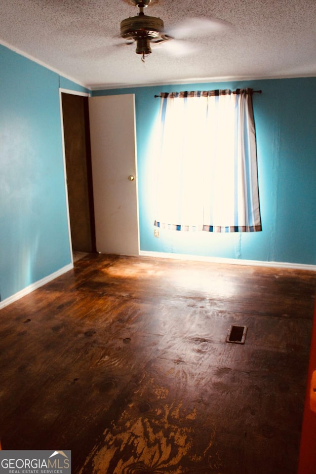 empty room featuring hardwood / wood-style flooring, ceiling fan, and a textured ceiling