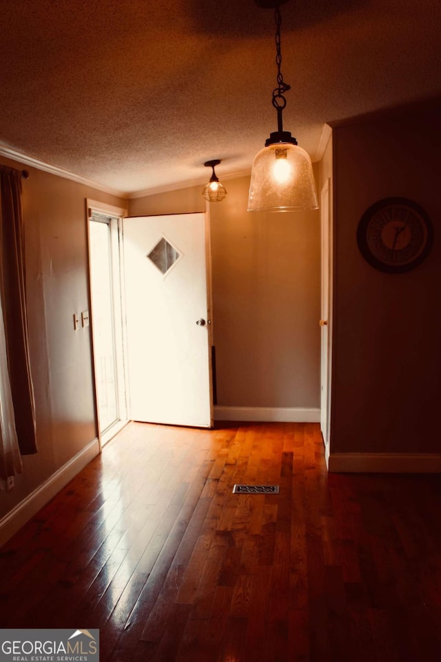 empty room featuring a textured ceiling and hardwood / wood-style flooring