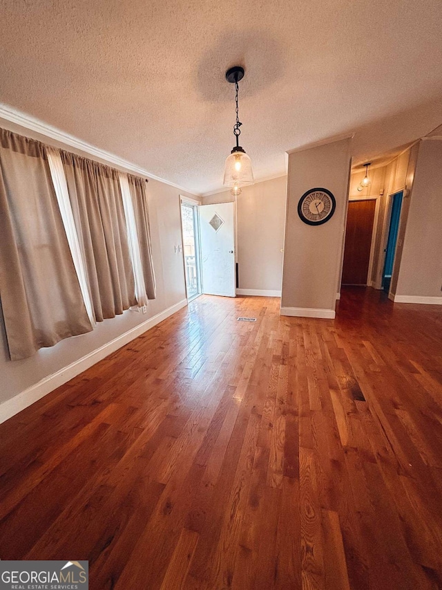 unfurnished room featuring hardwood / wood-style floors, crown molding, and a textured ceiling