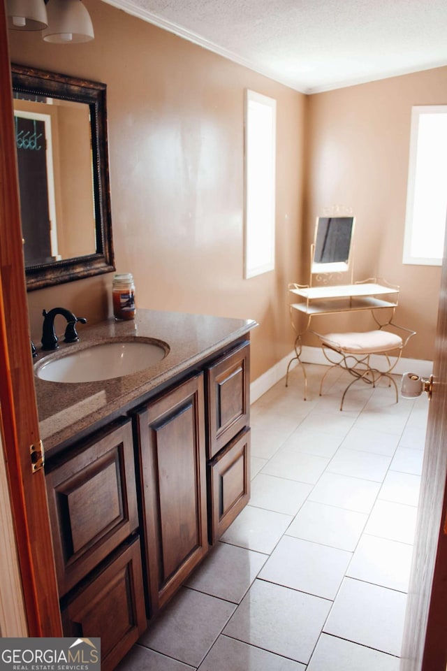 bathroom with tile patterned flooring, a textured ceiling, vanity, and a healthy amount of sunlight