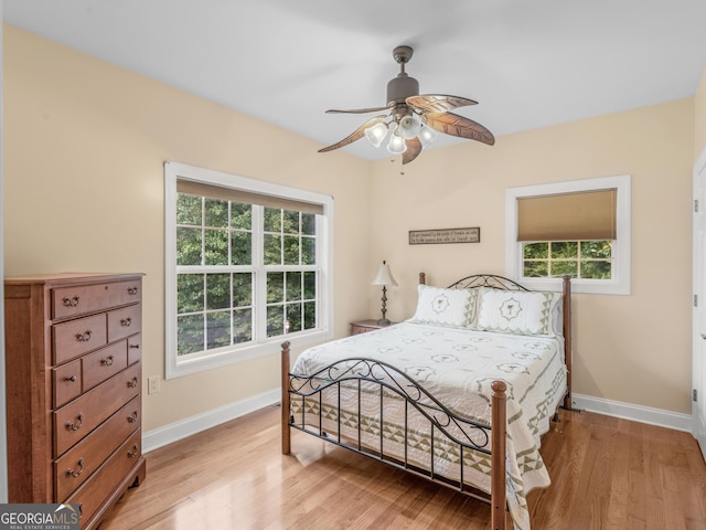 bedroom featuring multiple windows, light wood-type flooring, and ceiling fan