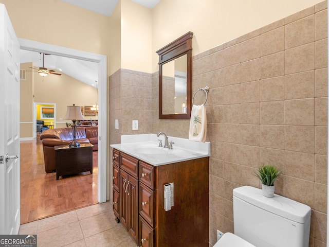 bathroom with vanity, tile patterned flooring, ceiling fan, toilet, and tile walls