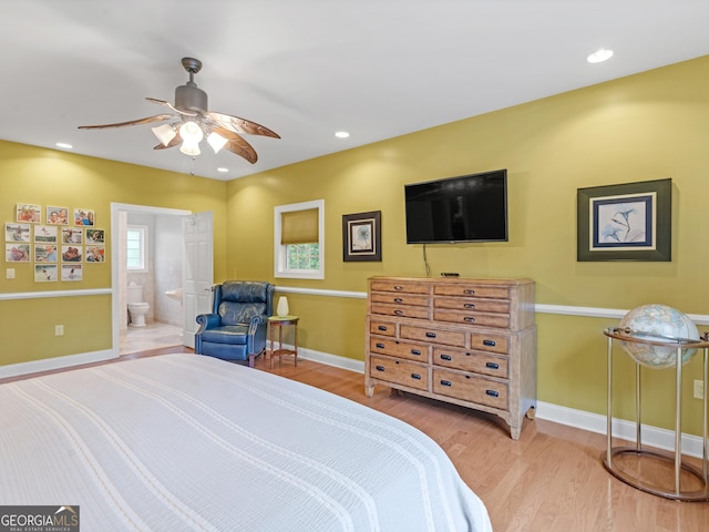 bedroom with light hardwood / wood-style floors, ensuite bath, and ceiling fan