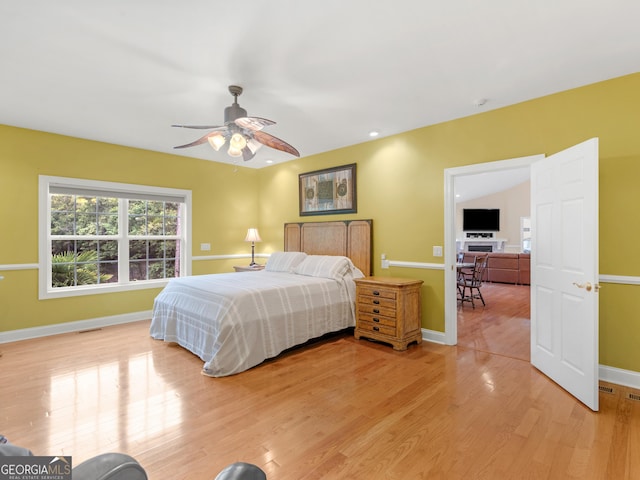 bedroom with ceiling fan, light wood-type flooring, and lofted ceiling