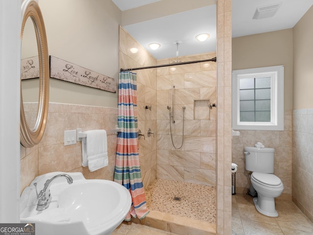 bathroom featuring toilet, tile walls, walk in shower, and sink