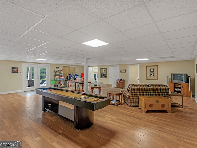 rec room with a paneled ceiling, french doors, and light hardwood / wood-style floors