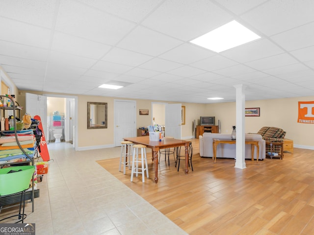 dining space with a paneled ceiling and light hardwood / wood-style floors