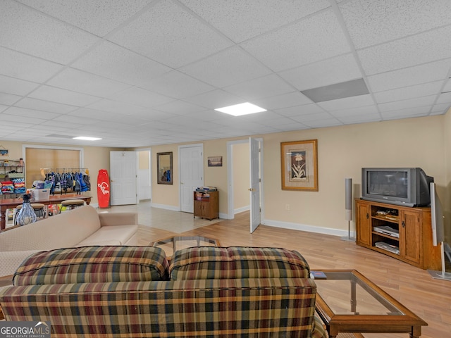 living room with light hardwood / wood-style floors and a drop ceiling