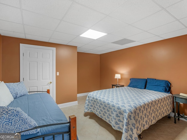 bedroom featuring a drop ceiling and light tile patterned flooring