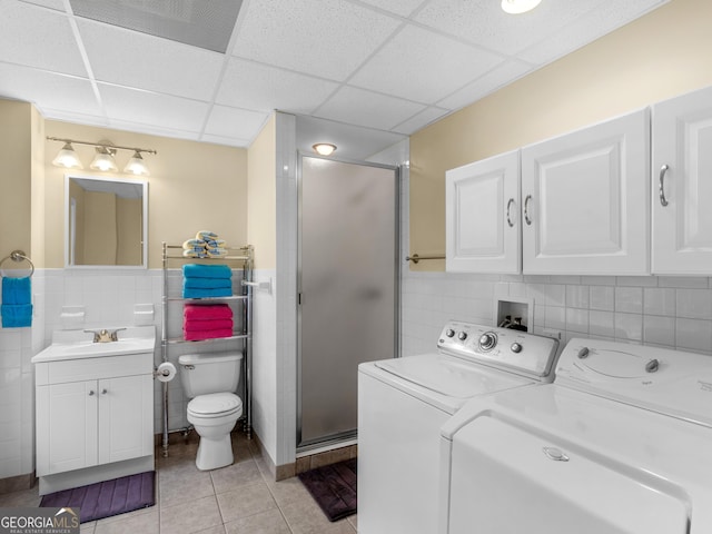 laundry room featuring independent washer and dryer, sink, and light tile patterned floors