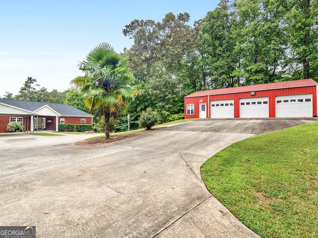 single story home featuring an outbuilding, a garage, and a front yard