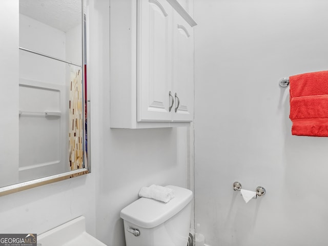 bathroom with a textured ceiling and toilet