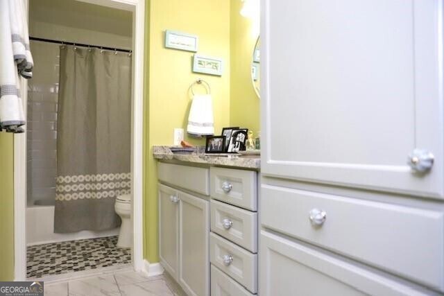 full bathroom with vanity, shower / bathtub combination with curtain, and toilet