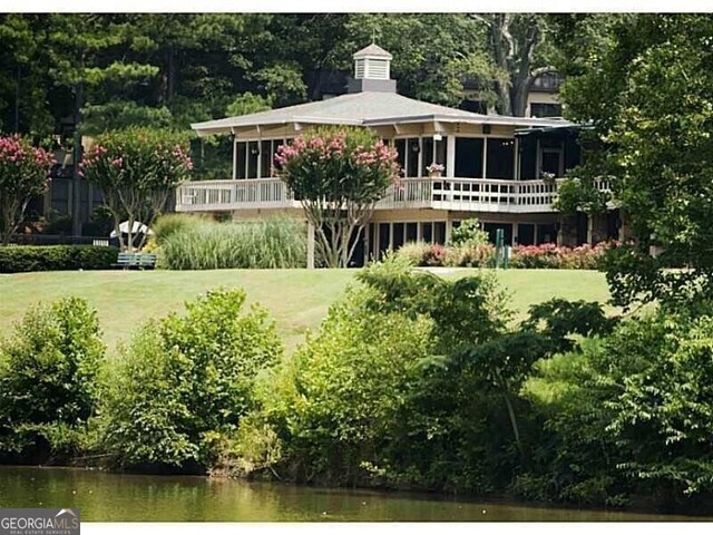 exterior space featuring a deck with water view and a yard