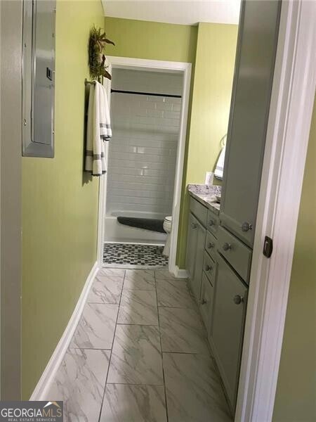 bathroom with vanity, electric panel, toilet, and walk in shower