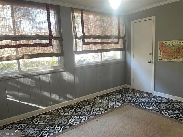 unfurnished room featuring tile patterned floors and ornamental molding