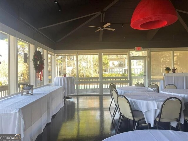 sunroom / solarium with vaulted ceiling, ceiling fan, and a healthy amount of sunlight