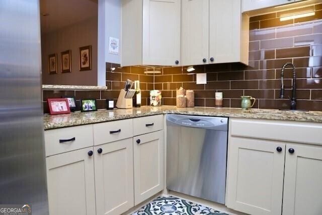 kitchen with sink, white cabinetry, stainless steel appliances, and tasteful backsplash