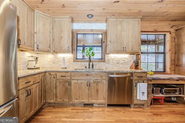 kitchen featuring appliances with stainless steel finishes, a sink, wood ceiling, light wood-style flooring, and plenty of natural light
