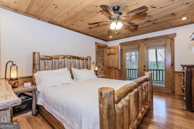 bedroom with a wainscoted wall, access to exterior, hardwood / wood-style floors, wood walls, and wooden ceiling
