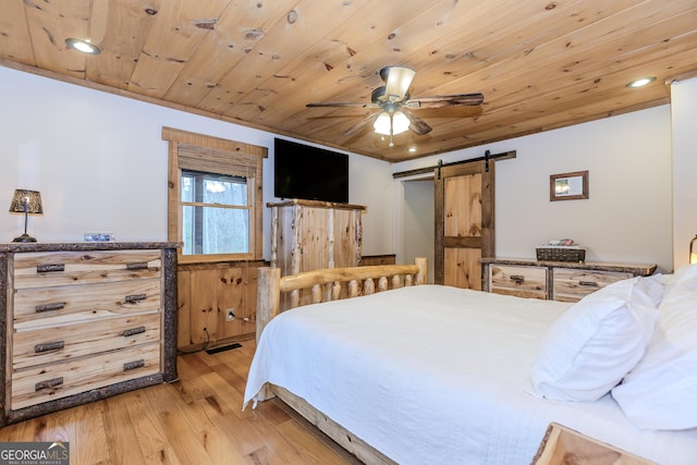 bedroom with a barn door, light wood finished floors, recessed lighting, wooden ceiling, and a ceiling fan