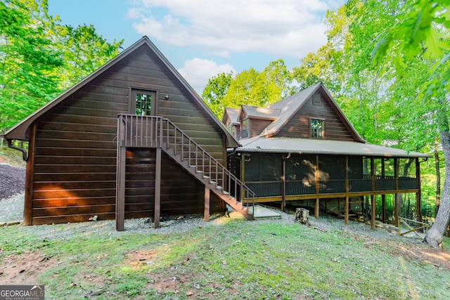 rear view of property with a sunroom and stairs