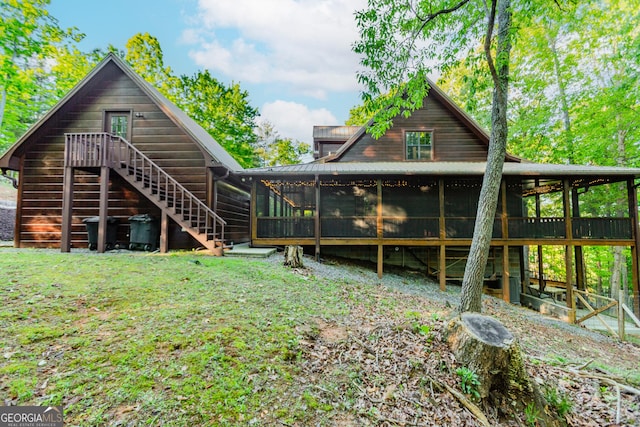 rear view of property with a sunroom and stairway