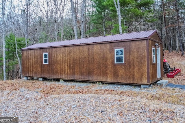view of outbuilding featuring an outdoor structure and a view of trees