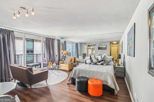 bedroom featuring access to outside, hardwood / wood-style flooring, and expansive windows