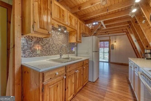 kitchen with tasteful backsplash, light countertops, a sink, and stove