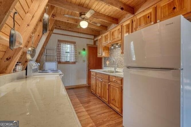 kitchen with white appliances, wooden ceiling, backsplash, light countertops, and a sink