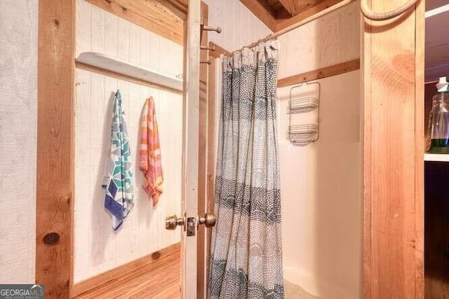 bathroom with a shower with curtain and wood finished floors