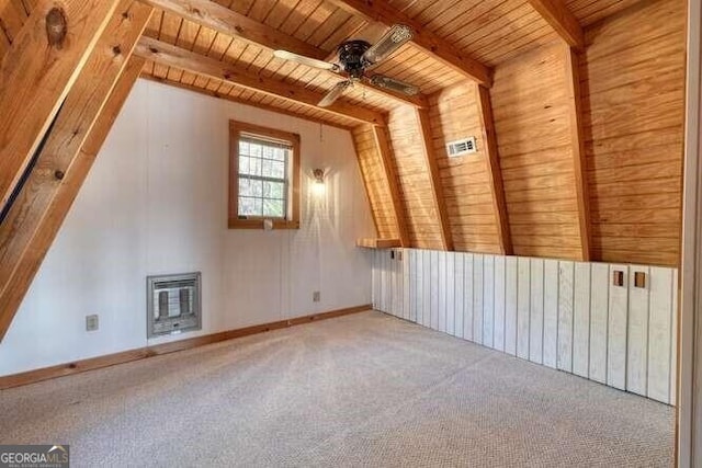 additional living space with vaulted ceiling with beams, a ceiling fan, wood ceiling, heating unit, and carpet