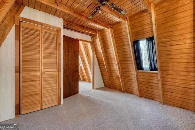 interior space featuring wooden ceiling, carpet flooring, wood walls, and beam ceiling