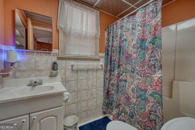 bathroom featuring toilet, tile walls, and vanity