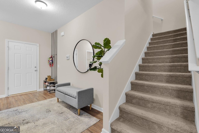 foyer entrance featuring a textured ceiling and hardwood / wood-style flooring