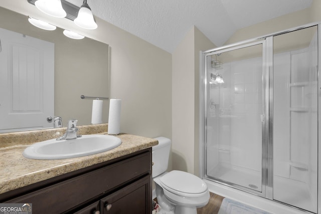 bathroom with a textured ceiling, toilet, a shower with shower door, and lofted ceiling