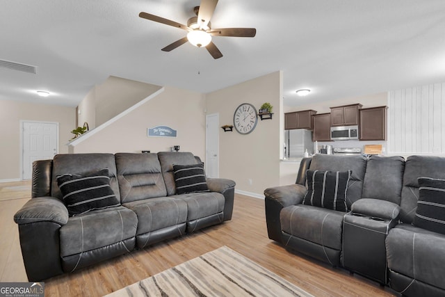 living room with light hardwood / wood-style flooring and ceiling fan